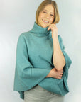 Woman wearing a sea green wrap poncho