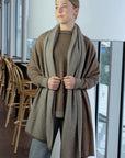 Woman wearing a long brown wrap in an indoor setting