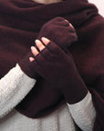 A pair of merino fingerless gloves in red, being worn by a person.