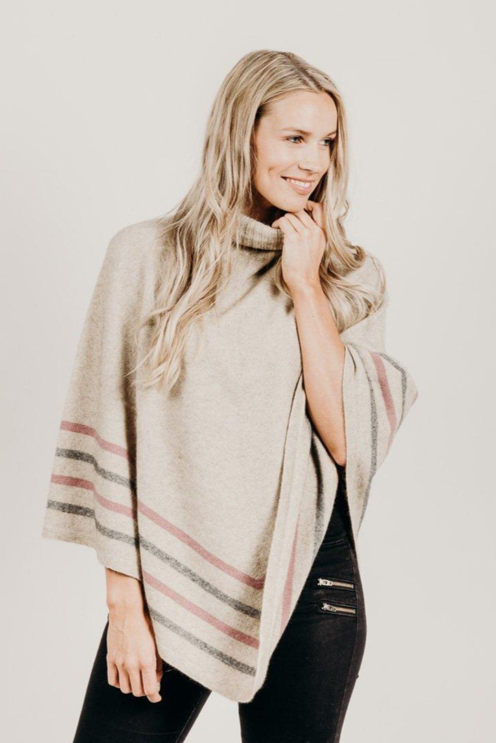 Woman wearing a Lichen Merinosilk Stripe Poncho with black pants