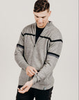 Man wearing a gray zip-up hoodie with black accents on a light gray background