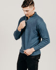 Man wearing a blue sweater against a plain background
