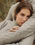 a couple wearing lichen cable sweaters