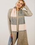 Woman wearing a long, patterned scarf with a neutral background