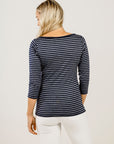 Woman wearing a black and white striped long-sleeve top on a plain background