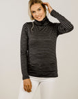 Woman wearing a black and gray striped turtleneck sweater against a plain background