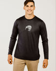 A male model wearing a long sleeve black Merino wool t-shirt with a white print of a Kiwi bird on the front and beige pants.