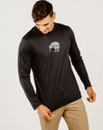 Man wearing a black long-sleeve shirt with a logo on a white background