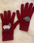 Red gloves with kiwi and sheep designs on a white fur background