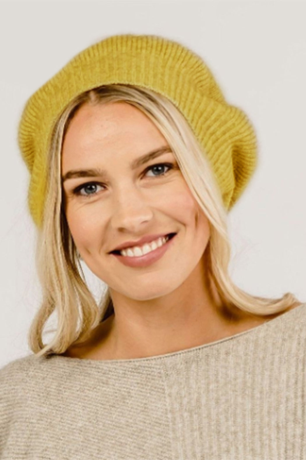 A woman wearing a yellow Merinosilk beret hat.