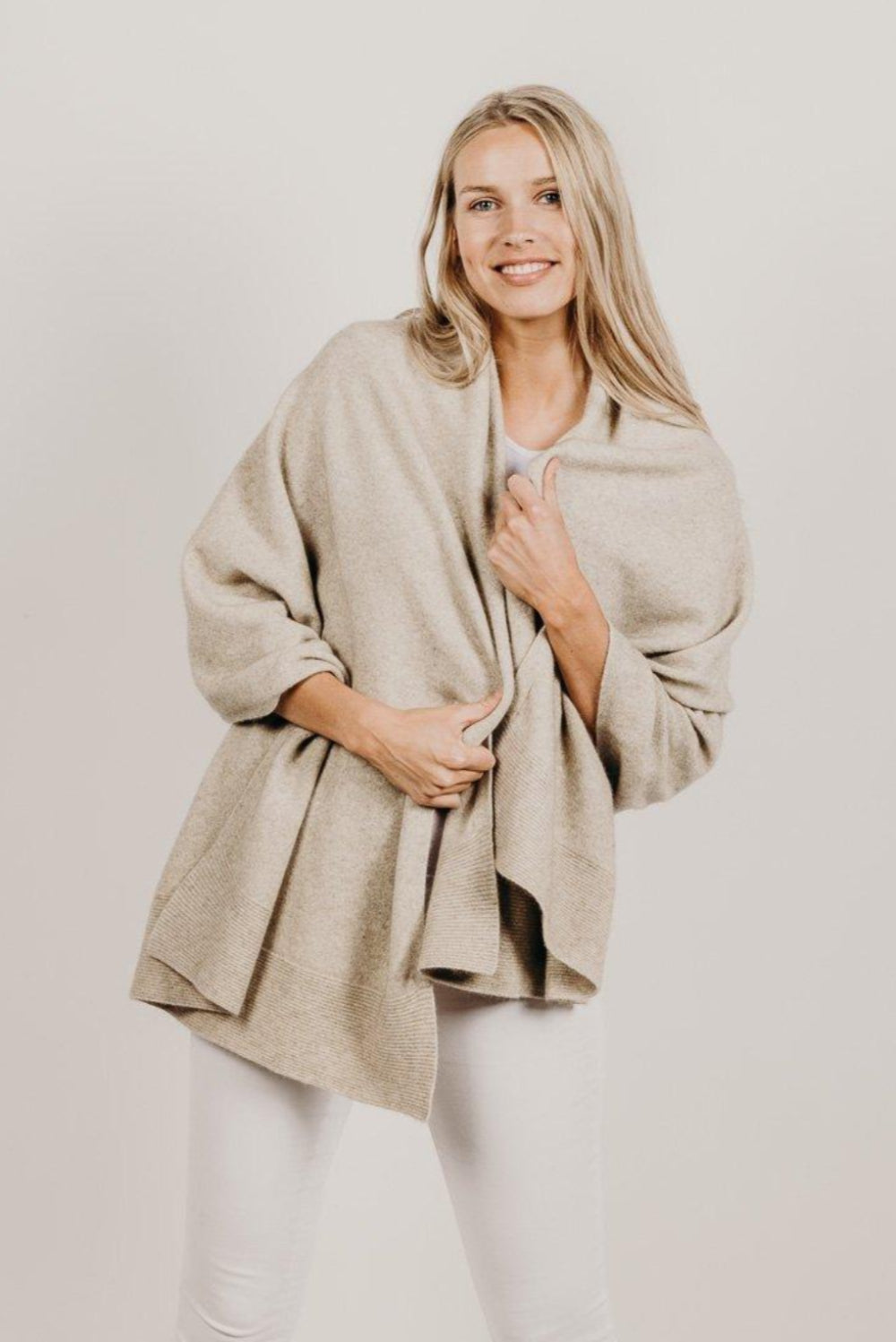 Woman wearing a Lichen Merinosilk Ribbed Wrap with white pants